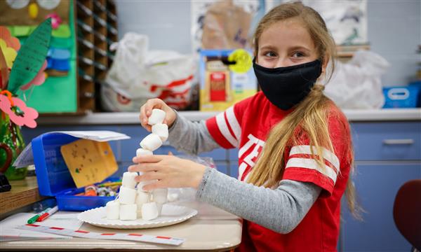 Girl builds marshmallow tower